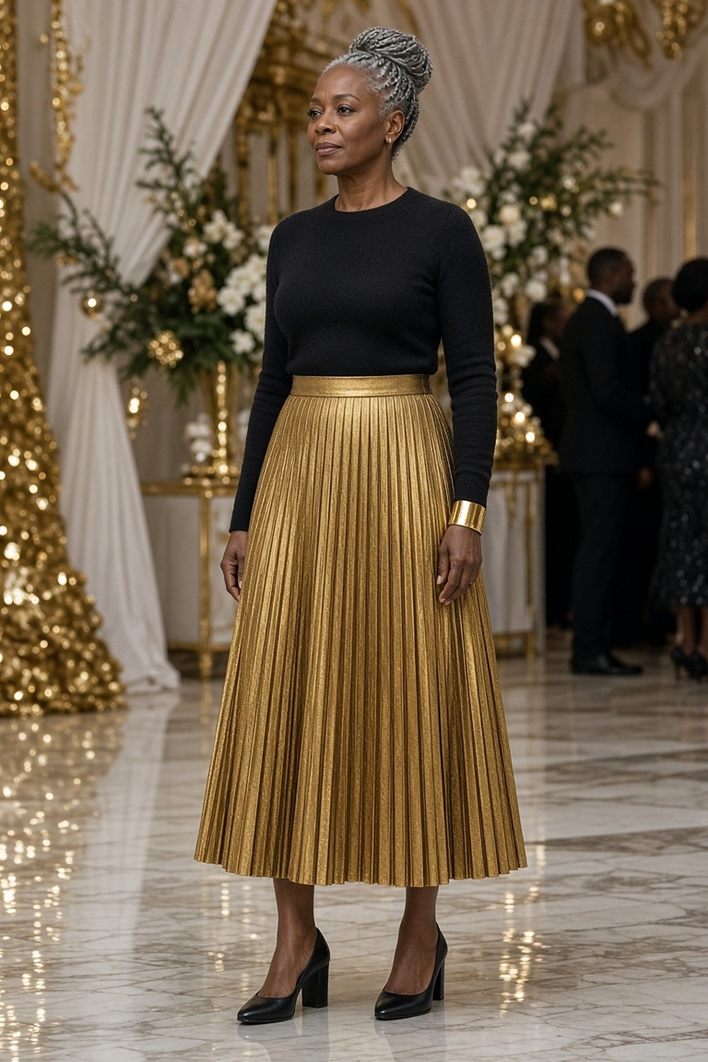 Woman over 50 in a gold metallic pleated midi skirt and black knit