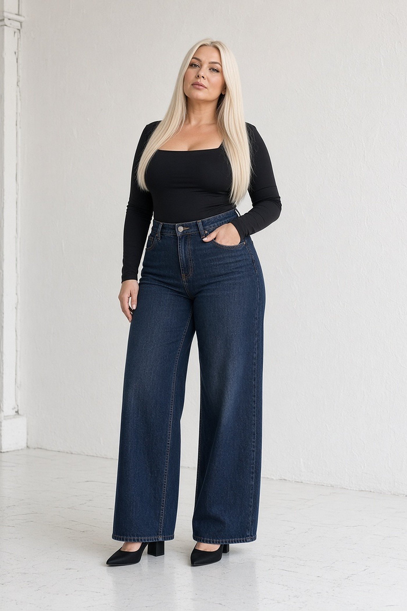 Curvy woman in a black bodysuit and dark wide-leg jeans