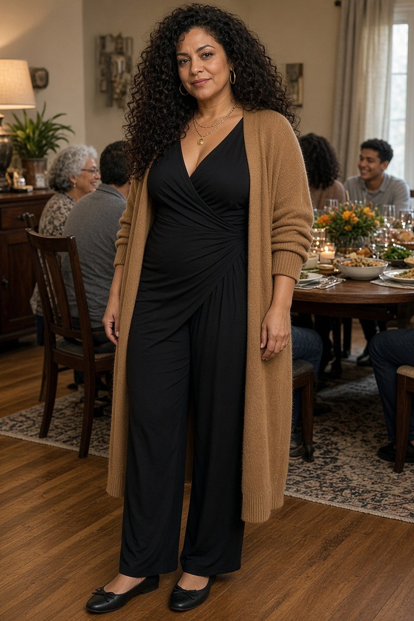 Woman over 40 in black jumpsuit and long camel cardigan