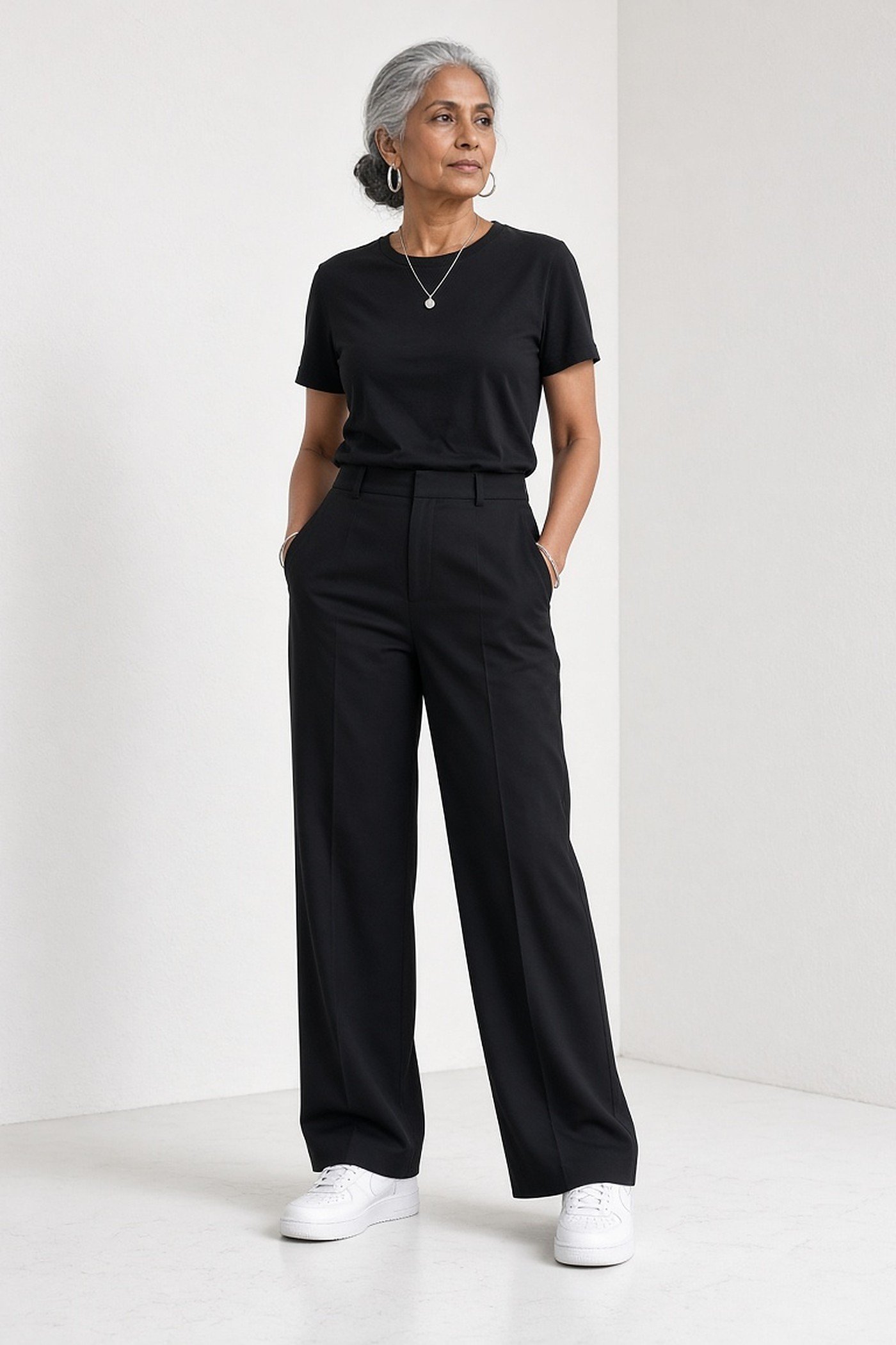 Woman over 50 in an all-black outfit with crisp white sneakers